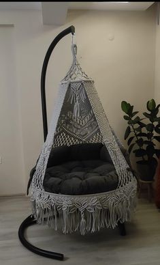 a white hanging chair with black cushions