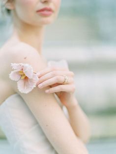 a woman in a white dress holding a flower