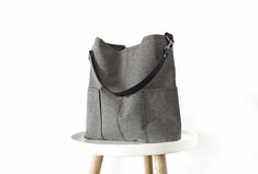 Stylish and classic grab and go large hobo bag.  Great everyday bag that will keep you organized with plenty of pockets on the inside and two pockets on the outside. Light, sturdy and comfortable on the shoulder due to the wide strap.  *Made of durable upholstery canvas fabric in medium gray color.  *Cowhide leather strap in black.  *Fully lined with solid gray cotton fabric . * 4 large slip inner pockets * Magnetic button closure  Dimensions: Width: 13.5 in (35 cm) Height: 13 in (33 cm) Bottom Everyday Bucket Bag With Double Handle And Pockets, Everyday Tote Bucket Bag With Zipper Pocket, Everyday Hobo Tote Bag With Pockets, Tote Hobo Bag With Pockets, Everyday Use Hobo Tote Bag With Pockets, Everyday Tote Hobo Bag With Pockets, Everyday Bucket Bag With Pockets, Everyday Crossbody Hobo Bag With Pockets, Everyday Double Handle Hobo Bag With Pockets