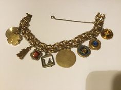 Beautiful 12kt gold filled charm bracelet with 9 charms and safety clasp. Woven links.size 7.5 inches. Charm #1- gold tone tea cup and saucer, #2- 1/20 10kt  Mount Mary College,#3- 1/20 10kt Milwaukee Wisconsin,#4- 1/20 12kt Florida Souvenir,#5- Moveable Sail Boat,#6- possibility a sorority charm ,#7- 1/20 12kt Dane craft Windmill,#8-four leaf clover and #9- Anniversary Pin. In great pre owned condition. Gold Elegant Charm Bracelet, Antique Yellow Gold Bracelets With Vintage Charm, Antique Gold Bracelet With Lobster Clasp, Vintage Charm Yellow Gold Bracelet, Vintage 14k Gold Jewelry With Charms, Vintage Yellow Gold Charm Bracelet, Vintage 14k Gold Bracelet, Vintage Handmade Gold-tone Jewelry, Handmade Vintage Gold-tone Jewelry