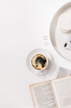 an open book and cup of coffee on a table