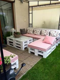 an outdoor patio made out of pallets with pink cushions and pillows on the back