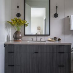 a bathroom with a sink, mirror and towel rack on the wall above it's counter