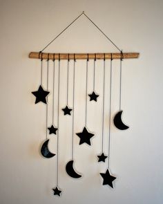 a wind chime with black stars and crescents hanging from it's side