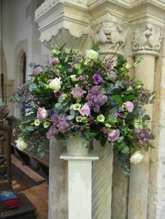 a vase filled with lots of purple and white flowers