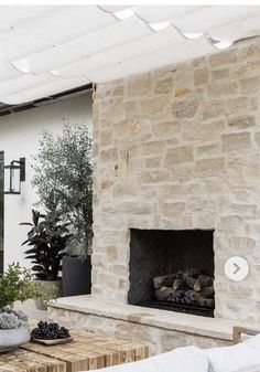 a living room with a stone fireplace and white couches