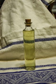 an empty bottle sitting on top of a table next to a white towel and pillow