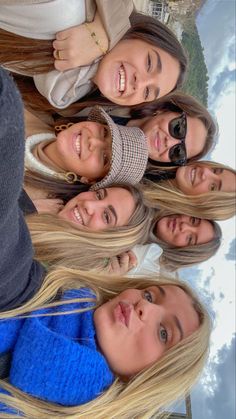 a group of young women standing next to each other in front of a sky background