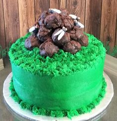 a cake with green frosting and chocolate cookies on top, sitting on a table