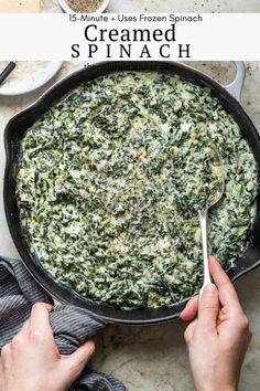 spinach in a cast iron skillet being stirred with a spoon to cook it