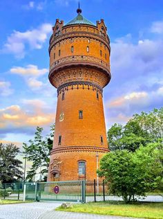 a tall brick tower sitting on top of a lush green field