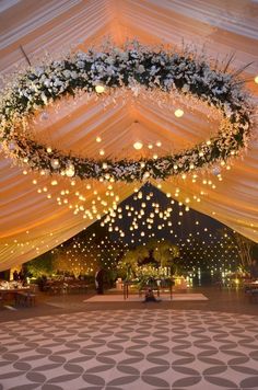 the inside of a tent decorated with lights and flowers