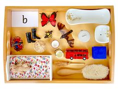 a wooden tray filled with lots of different types of toys and items on top of it