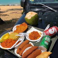 there is a tray with food on it next to a can of soda and some drinks