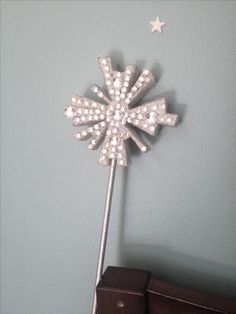 a metal pinwheel on top of a wooden table next to a wall mounted clock