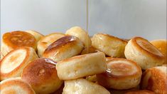 bread rolls are being drizzled with honey