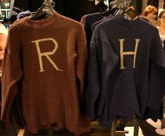 two sweaters with the letters r and h on them are hanging in a store