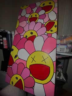 a painting of pink flowers with yellow faces on it's sides and one eye open