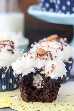 chocolate cupcakes with white frosting and nuts on top