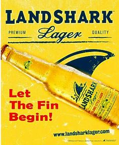 an advertisement for land shark lager beer on the side of a yellow sign that reads, let the fin begin