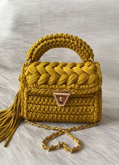 a yellow handbag with a tasseled handle on a white furnishing