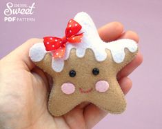 a hand holding a small felt ginger with a red bow