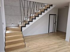 an empty room with wooden floors and stairs