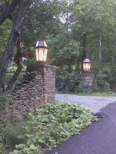 two lamps are on top of a stone wall