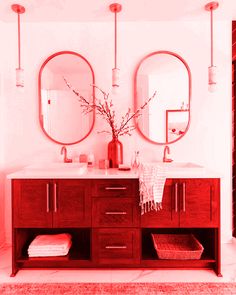 a bathroom with two round mirrors above the sink and red cabinetry on the wall