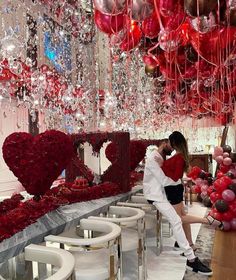 a man and woman kissing in front of valentine's day decorations