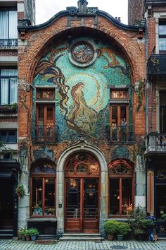 an old building with a mosaic on the front and side wall, along with potted plants