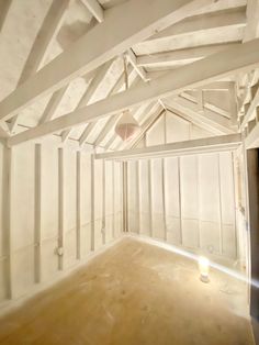 an unfinished room with white walls and wood floors is seen in this image, the light shines on the floor