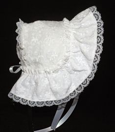 A beautiful Victorian style baby or doll bonnet. Fabric is white cotton raised embroidery. Lining is white . Bonnet has an extended back and is trimmed with white lace. Bows and extra long ties are made of white double sided satin ribbon. Size/ Measurement from under ear lobe around top of head to under other ear lobe 0-3 months / 11 inches 3-6 months / 12 inches 6-9 months / 13 inches 9-12 months / 14 inches 12-18 months / 15 inches 18-24 months / 16 inches Fitted White Bonnet With Lace Trim, Fitted White Bonnet For Baptism, White Fitted Bonnet For Baptism, White Adjustable Lace Bonnet, White Lace Adjustable Bonnet, Fitted Cotton Bonnet With Lace Trim, White Cotton Bonnet For Baptism, White Fitted Vintage Bonnet, White Bonnet