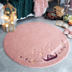 a pink rug with writing on it in the middle of a room next to a bed