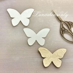 three butterfly cut outs sitting on top of a table