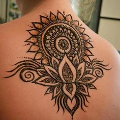 the back of a woman's neck with an intricate design on it