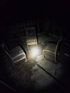 two chairs sitting next to each other in the dark