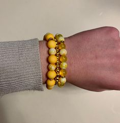 Beautiful trio of bracelets comprised of bright yellow, clear yellow, yellow marble and gold beads. The largest beads are 10mm. The clear and marble yellow beads are 8mm round glass beads. The smaller beads are 5mm iron round beads. The bracelets are approximately 17-17.5 cm in length each. Yellow Beaded Bracelet, Beaded Jewelry Bracelets, Diy Beaded Bracelets, Yellow Bracelet, Bracelet Sets, Beaded Bracelets Tutorial, Bracelets Design, Bracelet Display, Beads Bracelet Design