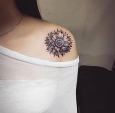 a woman with a sunflower tattoo on her left shoulder and right arm behind her back