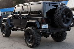 a black jeep parked in a parking lot