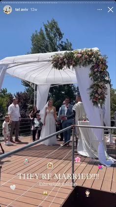 a couple getting married at their wedding ceremony on the deck with friends and family around them