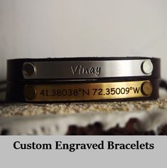 two personalized bracelets sitting on top of a cake with the words, custom engraved bracelets