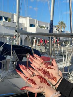 a woman's hands with hendix painted on them and boats in the background