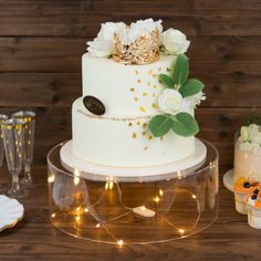 a wedding cake with white flowers and gold decorations