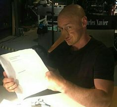 a man sitting at a table reading a piece of paper with a knife sticking out of it