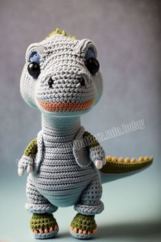 a crocheted stuffed animal is posed in front of a gray background