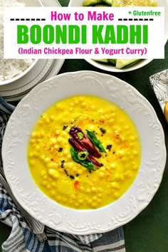 a white bowl filled with yellow soup next to plates of rice and other food on a table