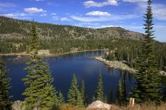 a lake surrounded by pine trees in the mountains