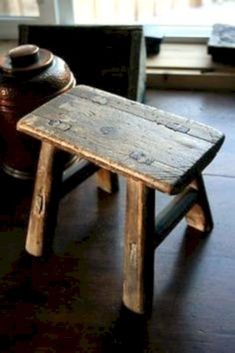 a small wooden stool sitting on top of a hard wood floor