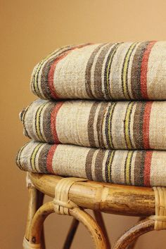 a stack of towels sitting on top of a wicker chair